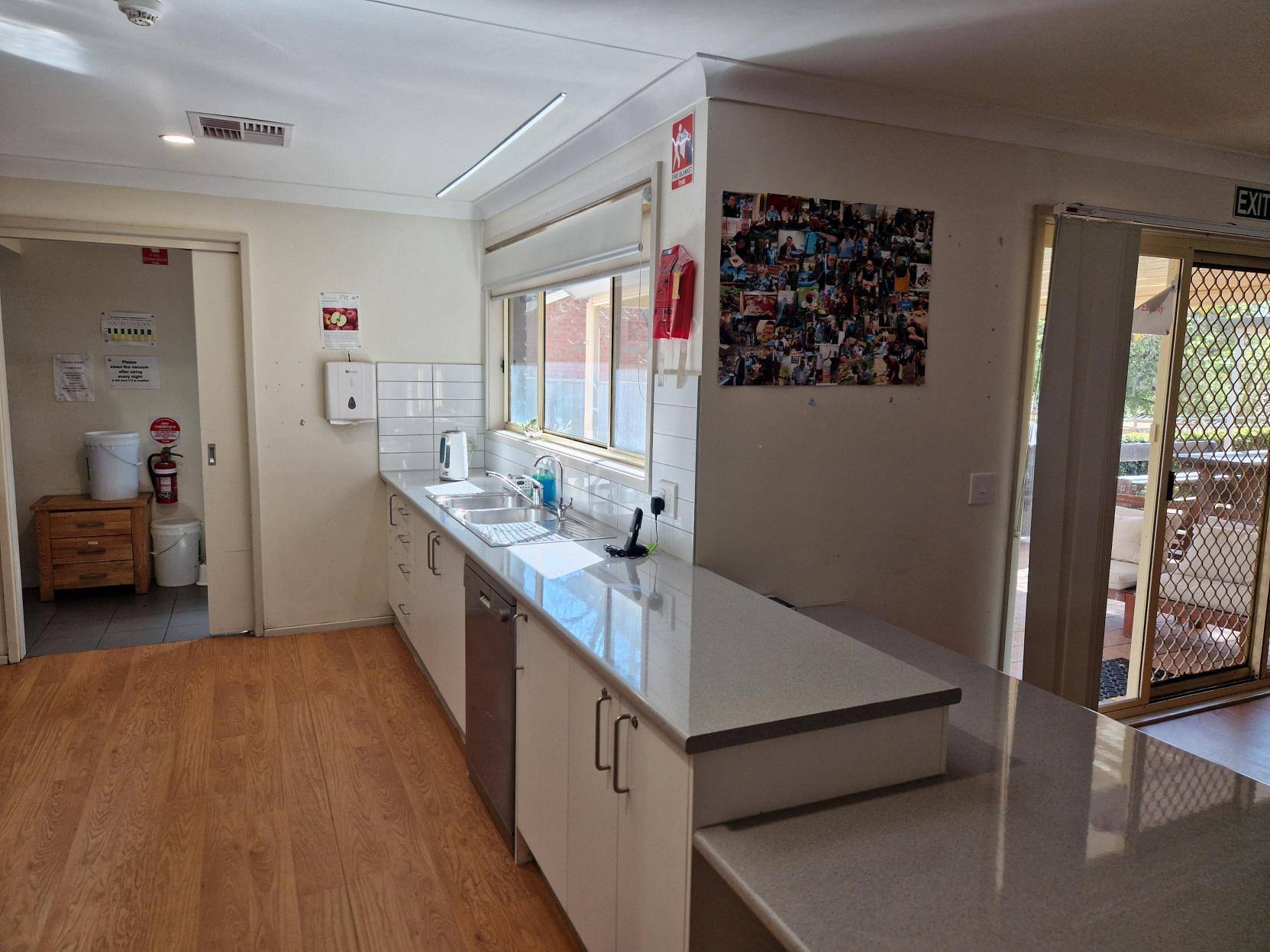 Kitchen featuring a sink under a big window, letting lots of light in.