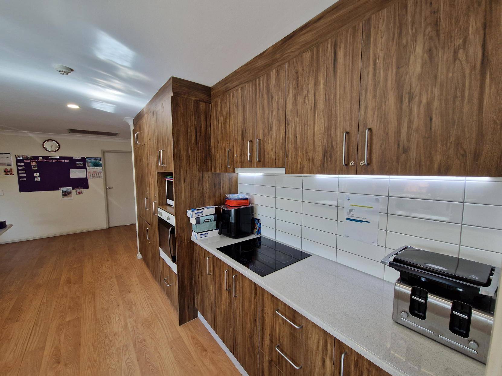 A large kitchen with brown cupboards and white countertops.