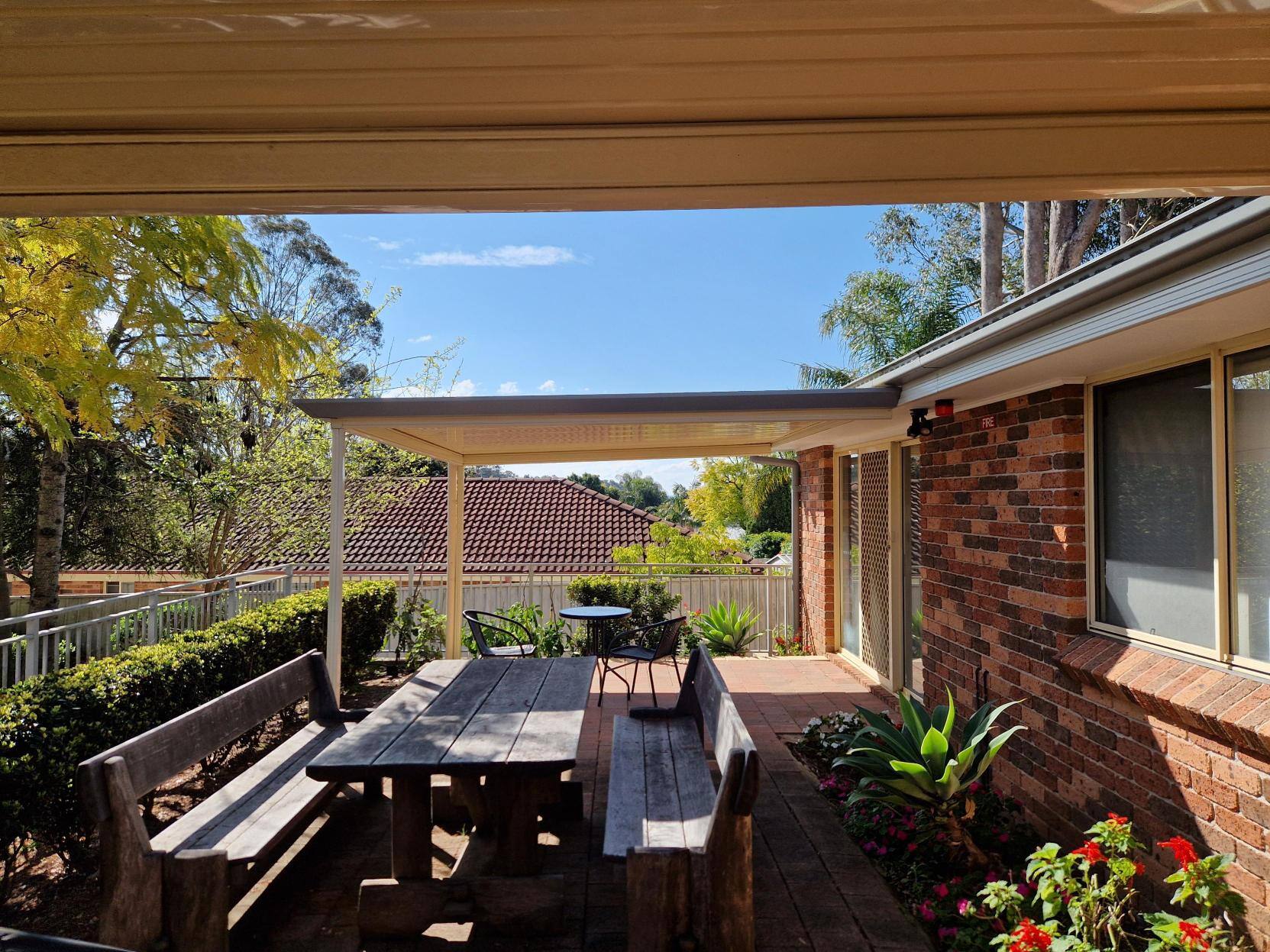 A welcoming patio with a table and chairs, shaded by a roof for outdoor dining.