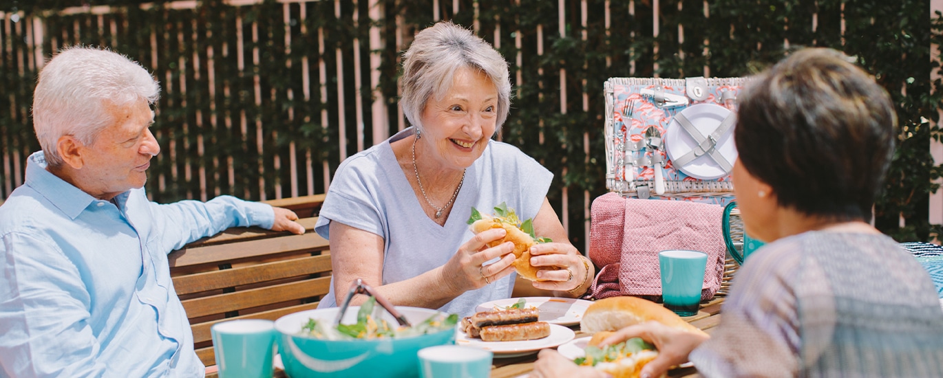 Smiling seniors enjoying a conversation over food at the Retirement Living Open Day in Carlingford